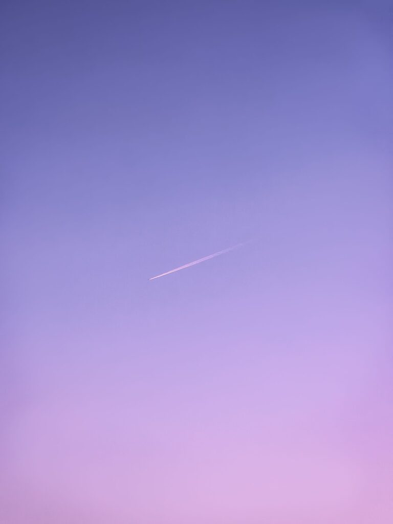 A thin pink contrail across a soft purple dusk sky. Photo: Sherif Emad / Pexels