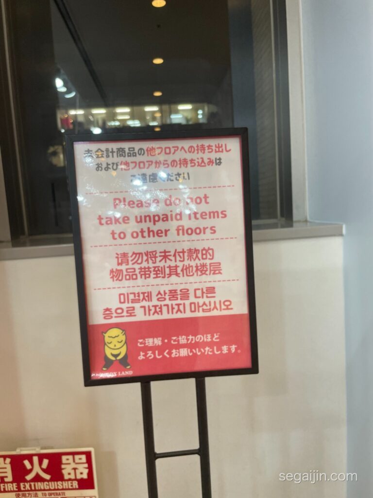 A sign in English, Japanese, Chinese and Korean asking customers not to take unpaid items to other floors