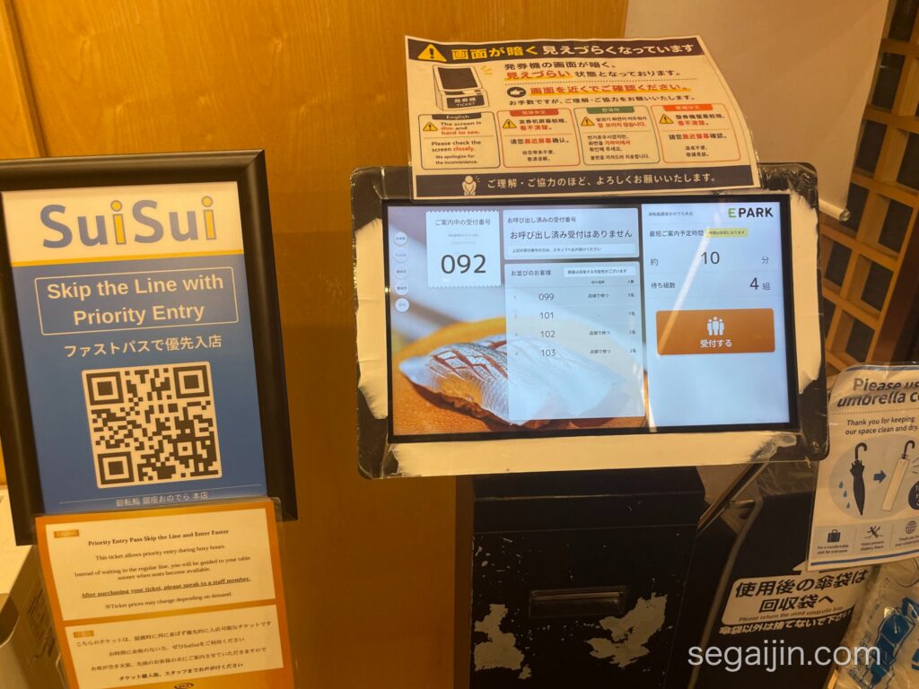 The waiting-list ticket machine at the restaurant entrance, next to the SuiSui priority entry sign