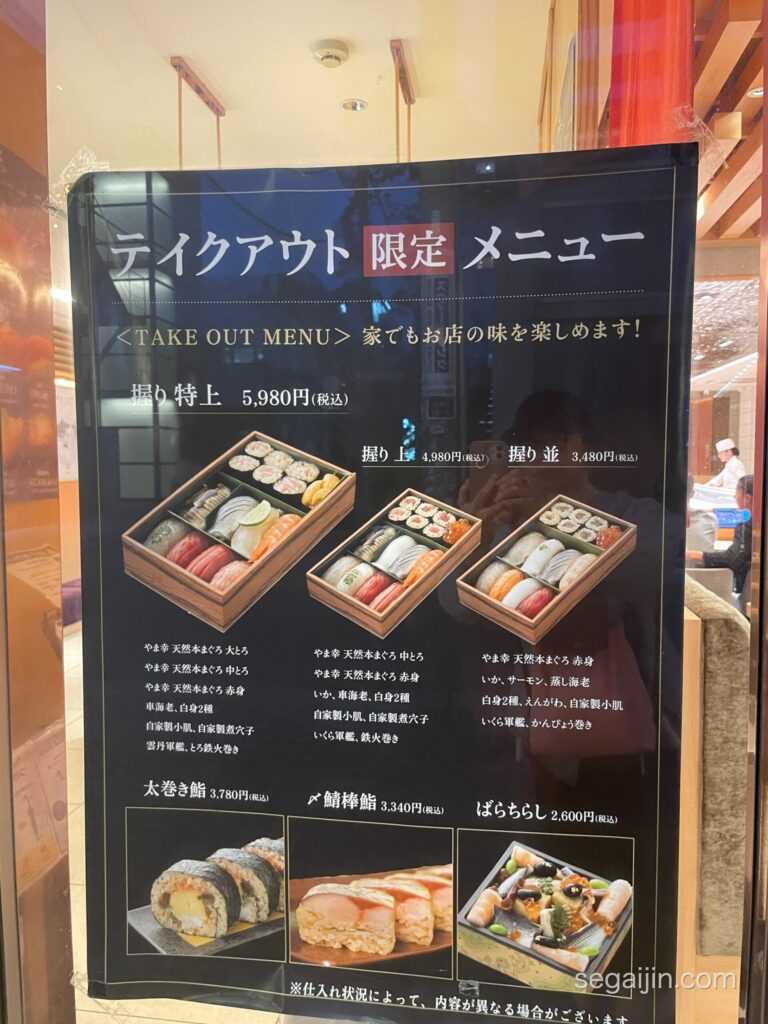 The takeout menu poster outside the restaurant, showing nigiri sets and prices
